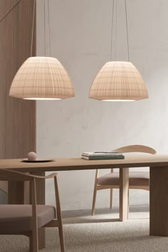 two lamps hanging over a wooden table in a room