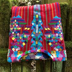 a colorful blanket hanging on a wooden fence