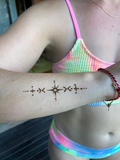 a woman's arm with a tattoo on it that has three crosses drawn on it