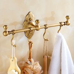 a towel rack with two hooks and three towels hanging from it's sides on a wall