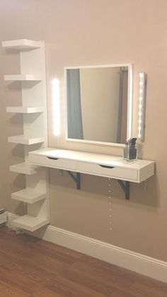 a white dressing table with lighted mirror and shelves