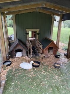 there is a chicken coop with two chickens in it and one on the other side