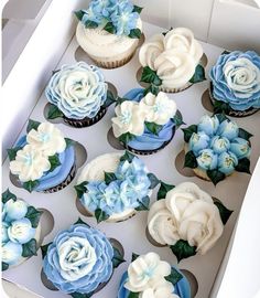 cupcakes decorated with blue and white flowers in a box