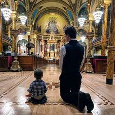 a man and child sitting on the floor in a church