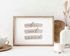 a framed print with the words relax and be kindl on it next to some vases