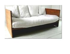 a white couch sitting on top of a hard wood floor next to a wooden frame