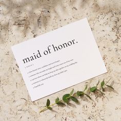 a piece of paper with the words maid of honor on it next to a plant