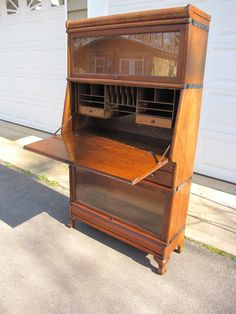 an old wooden desk sitting on the sidewalk in front of a garage