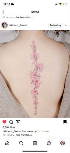 the back of a woman's neck with pink flowers on her left side and behind it