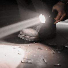 a close up of a person working on a shoe with a light shining through it