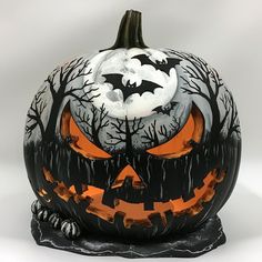 a carved pumpkin with bats and trees on it's face is shown in front of a white background