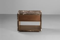 an end table with a marble top and shelf on one side, against a gray background