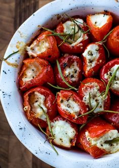 a white bowl filled with sliced tomatoes and cheese