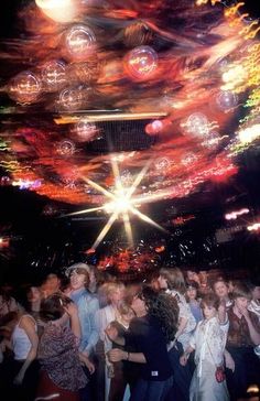 a group of people standing around each other in front of a ceiling covered with bubbles