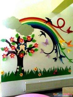 the wall is decorated with colorful paper cutouts and birds flying over trees, flowers, and rainbows