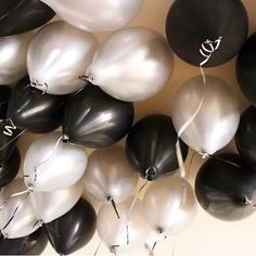 many black and white balloons are in the air