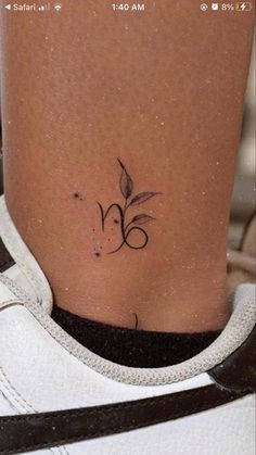 a small tattoo on the side of a woman's leg, with a flower