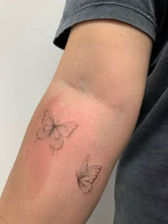 a person with a tattoo on their arm and two butterflies in the middle of his arm