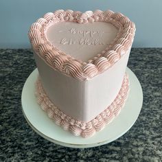 a pink heart shaped cake on top of a white plate