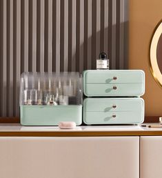 three drawers are stacked on top of each other in front of a wall with vertical blinds