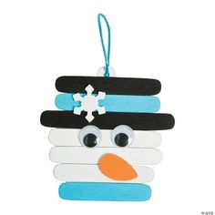 a paper snowman ornament hanging from a string