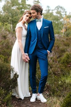 a man in a blue suit and woman in a white dress