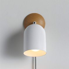 a white wall light with a wooden base and dimmer on the side, against a white wall