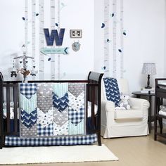 a baby crib with blue and white quilts on it