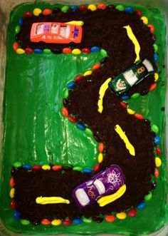 a birthday cake with cars on it in the shape of a number 3, made to look like a race track