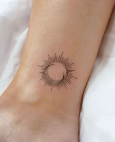 a woman's foot with a small sun tattoo on the side of her leg