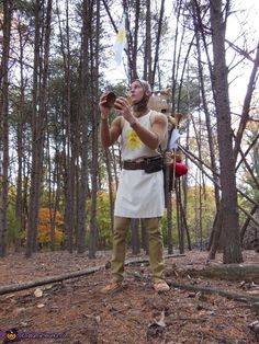 a man dressed as an ancient greek soldier in the woods