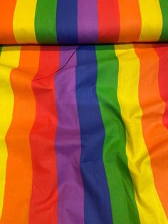 the rainbow colored fabric is laying on top of each other