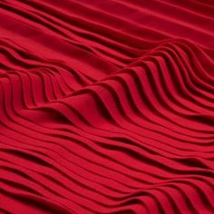 a red fabric with wavy lines on the top and bottom, as if it were pleating