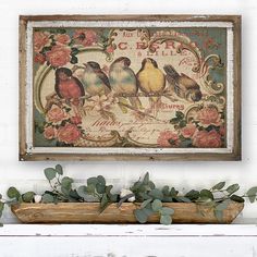 a painting hanging on the wall next to a planter filled with leaves and flowers