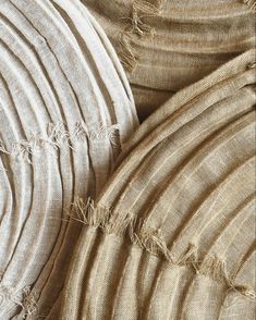 close up view of fabric with fringes on the bottom and sides, in neutral colors