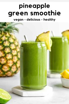 two glasses filled with green smoothie next to sliced pineapple