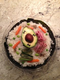 an avocado, ham, carrots, and other food items on top of rice