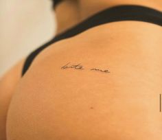 the back of a woman's stomach with a small tattoo on her left side