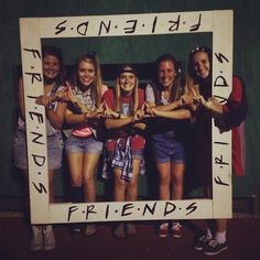 a group of young women standing next to each other in front of a photo frame