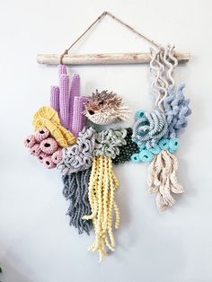 a wall hanging made out of crocheted yarn and rope with cactuses on it