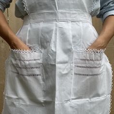 a woman in an apron with her hands on her hips, showing off the pockets