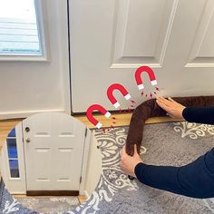 a woman is laying on the floor next to a door with two letters that spell out