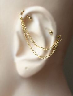 a close up view of a gold chain ear cuff