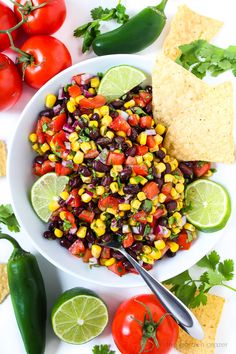 a white bowl filled with black bean and corn salsa next to tortilla chips