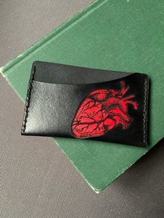 A handmade, hand dyed leather card wallet that can hold up to 5 cards. Vegetable tanned leather dyed Black and red with black waxed thread stitching. Black Leather Wallet Hand-stitched, Hand-stitched Black Leather Wallet, Hand-stitched Black Rectangular Wallet, Black Hand-stitched Rectangular Wallet, Black Rectangular Hand-stitched Wallets, Leather Card Wallet, Leather Dye, Anatomical Heart, Leather Card Holder