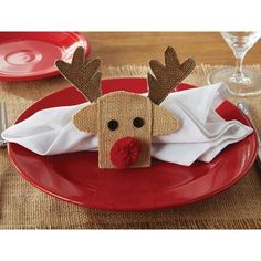 a red plate topped with a reindeer napkin holder