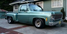 a green truck parked in front of a house