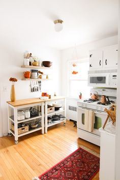 a white stove top oven sitting inside of a kitchen next to a wooden countertop