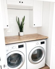 a washer and dryer in a small room with wooden counter top on the floor