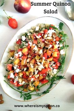 a white plate topped with salad next to fruit